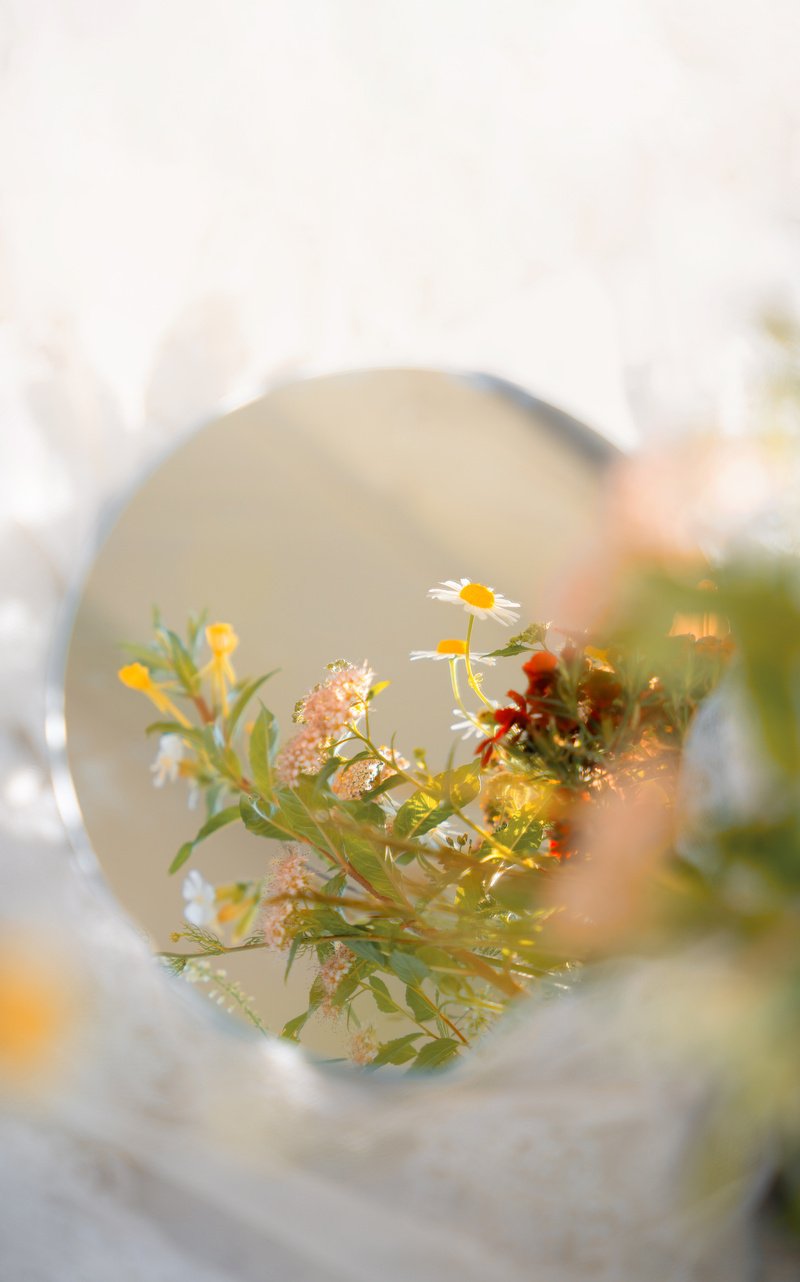 Wildflower reflection in mirror, warm sunset light and dreamy summer aesthetic